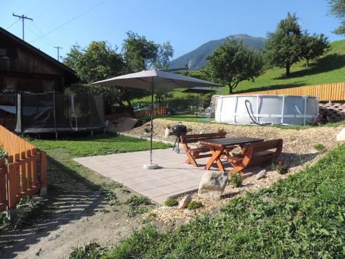 a picnic table with an umbrella in a yard at Ritzerhof Apartments in Stummerberg