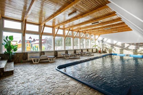 a swimming pool in a large room with a large window at Vila Maria Rustic Predeal in Predeal