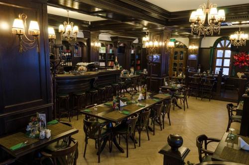 restauracja ze stołami i krzesłami oraz bar w obiekcie Conac Bavaria w mieście Buşteni