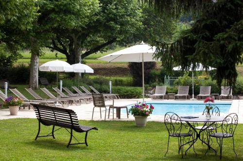 eine Gruppe von Stühlen und Tischen neben einem Pool in der Unterkunft Logis Auberge Saint Simond in Aix-les-Bains