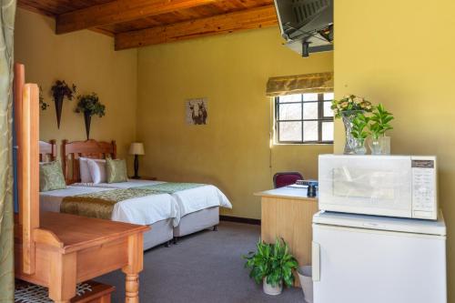 a hotel room with a bed and a microwave at Aberfeldy Bed & Breakfast in Midrand