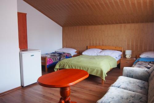 a room with two beds and a table and a chair at Pokoje u Wojtka Charbrowo in Charbrowo