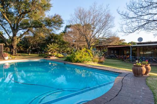a swimming pool in the yard of a house at Aberfeldy Bed & Breakfast in Midrand