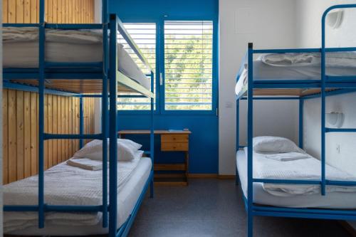 a room with three bunk beds and a window at Mont-Fort Swiss Lodge in Le Châble