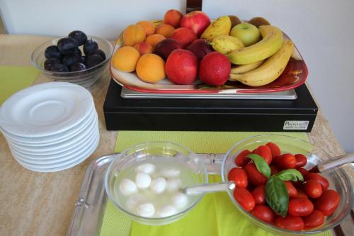 a table with a plate of fruit and a bowl of yogurt at Pension Silvia in Portorož