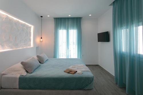 a bedroom with a large bed with blue curtains at Iades Studios & Apartments in Agia Anna Naxos