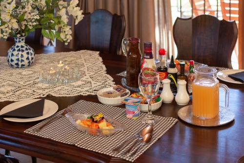 a table with a bowl of fruit and a pitcher of orange juice at Aberfeldy Bed & Breakfast in Midrand