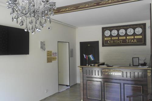 ein Restaurant mit einer Theke und einem Kronleuchter in der Unterkunft Orient Star Hotel in Taschkent