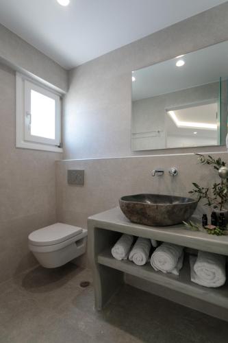 a bathroom with a sink and a toilet and a mirror at Iades Studios & Apartments in Agia Anna Naxos