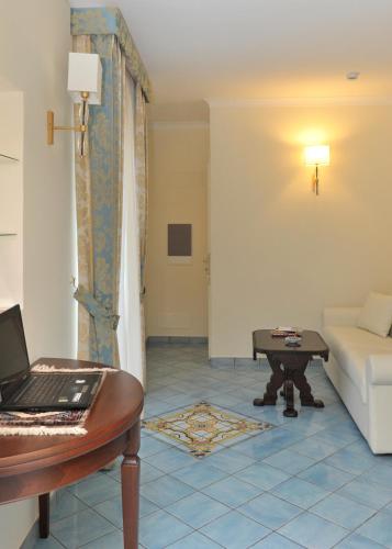 a living room with a laptop on a table and a couch at Hotel Santa Lucia in Minori