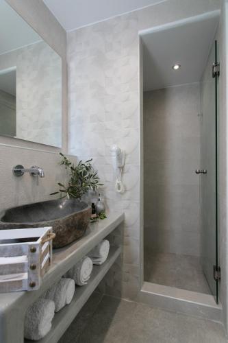 a bathroom with a sink and a glass shower at Iades Studios & Apartments in Agia Anna Naxos