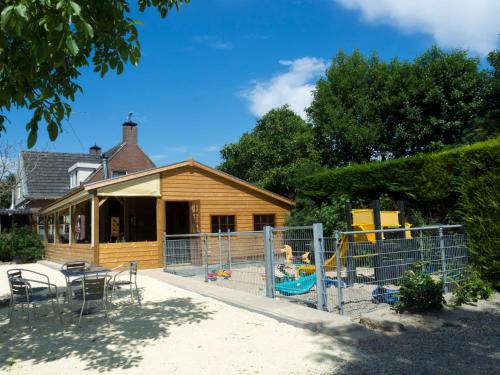 una casa con un parque infantil delante de ella en Camping De Grienduil en Nieuwland