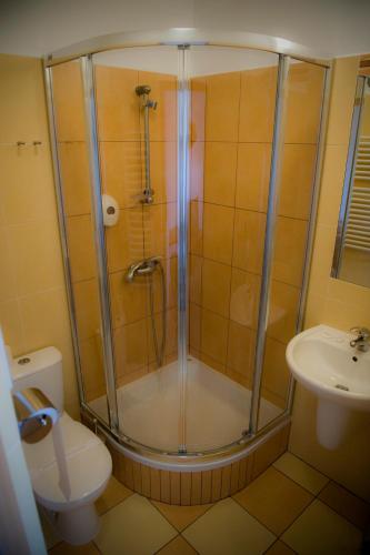 a bathroom with a shower and a toilet and a sink at Golf Hotel Lisia Polana in Pomocnia
