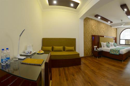 een woonkamer met een bank en een bed bij Hotel Pushp Villa Agra Taj East Gate in Agra