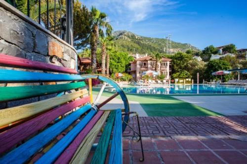 a colorful bench sitting next to a swimming pool at Club Pink Palace Hotel in Oludeniz