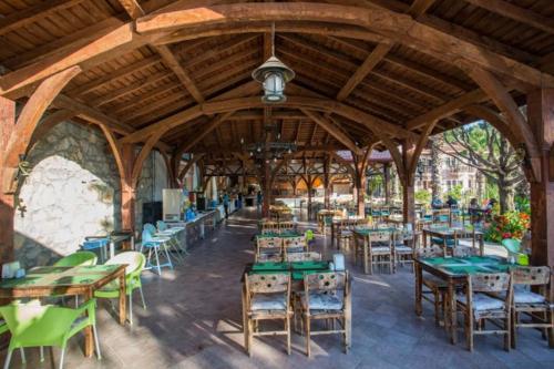 a restaurant with tables and chairs in a pavilion at Club Pink Palace Hotel in Oludeniz