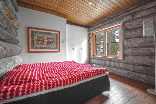 a red bed in a room with a window at Keloruka Cottage in Ruka