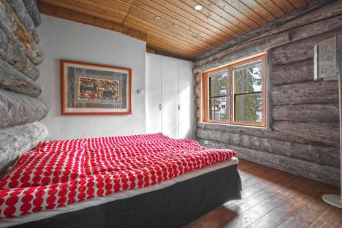 un letto rosso in una stanza con finestra di Keloruka Cottage a Ruka