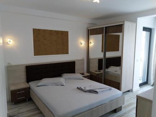 a bedroom with a large bed and a mirror at Apartament CAMEL in Eforie Nord