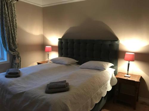 a bedroom with a large bed with two lamps at Moldegaard Farmhouse - Apartment B in Moldegard