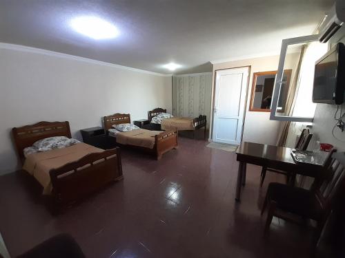 a living room with two beds and a table at Hotel Selika in Rustavi