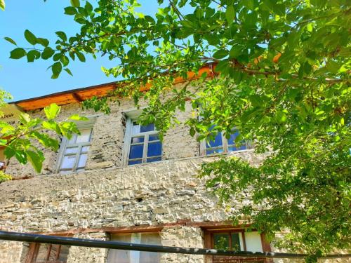 an old stone building with windows and trees at Panorama guesthouse Mata C. in Adishi