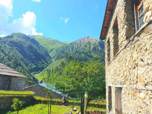 an old stone building with mountains in the background at Panorama guesthouse Mata C. in Adishi