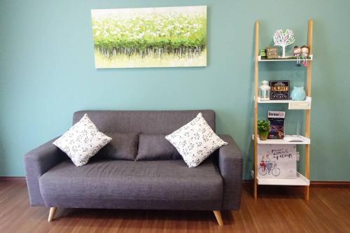a couch with two pillows on it in a room at 2BR Jazz Suites Vivacity Megamall Kuching Sarawak in Kuching