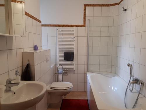 a bathroom with a tub and a toilet and a sink at City Pension Zwickau in Zwickau