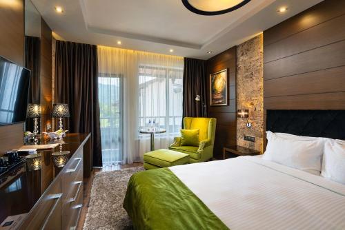 オレシャクにあるFamily Hotel Strannopriemnitzaのベッドと黄色い椅子が備わるホテルルームです。