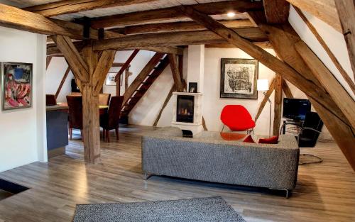 a living room with a couch and a red chair at Gästehaus Edelzimmer in Rothenburg ob der Tauber