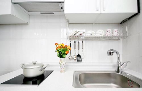 a kitchen counter with a sink and a vase of flowers at LaHoya Pension in Chuncheon