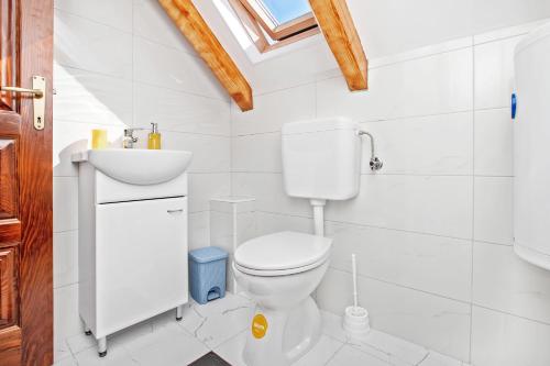 a white bathroom with a toilet and a sink at Apartments Isja in Tivat