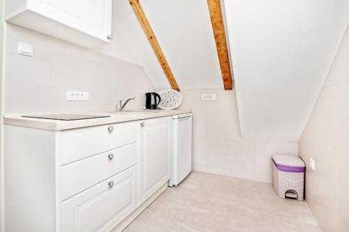 a kitchen with white cabinets and a sink at Apartments Isja in Tivat