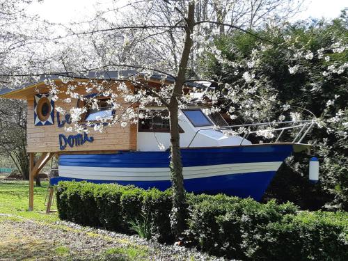 a blue and white boat parked next to a house at Le Domi in Dury