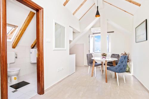 a room with a table and chairs and a toilet at Apartments Isja in Tivat