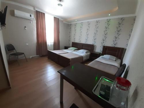 a room with two beds and a table with a telephone at Hotel Selika in Rustavi