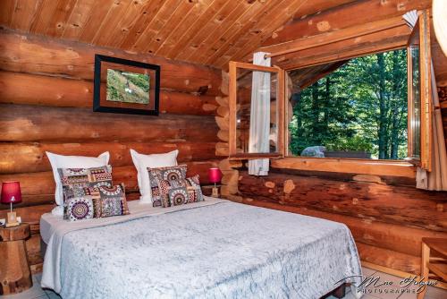 a bedroom with a bed in a log cabin at Le Couarôge Chalets et Appartements in La Bresse