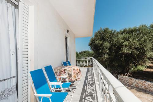 a balcony with blue chairs and a table at Olive yard house in Lithakia