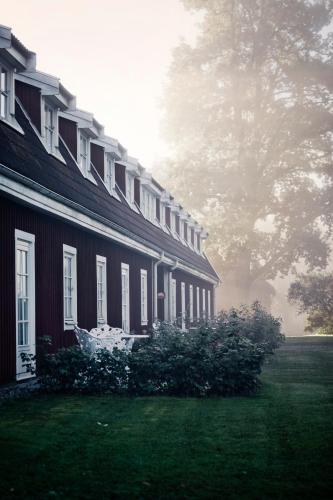 a house with a grass yard next to a building at Thoresta Herrgård in Bro