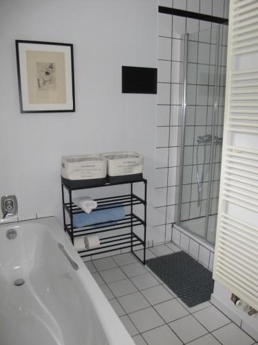 a white bathroom with a tub and a shower at Rossis Haus in Schneverdingen