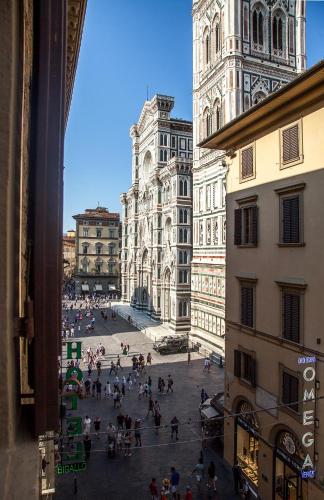 a group of people walking around a city square with a clock tower at Hotel Costantini in Florence