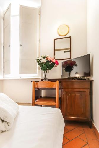a bedroom with a bed and a desk with flowers on it at Hotel Costantini in Florence