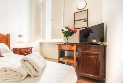 a bedroom with a bed and a tv on a desk at Hotel Costantini in Florence