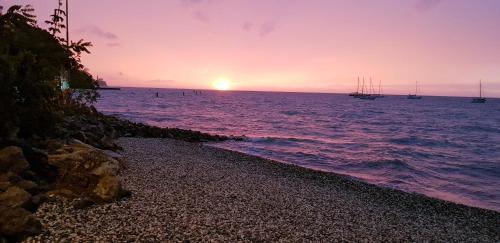 a sunset on the beach with boats in the water at Hotel Oleander - Oleander Resort in Strunjan