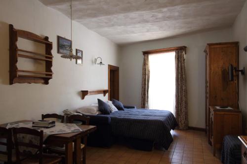 a bedroom with a bed and a table and a window at Residenza dei Maestri in Roccaraso