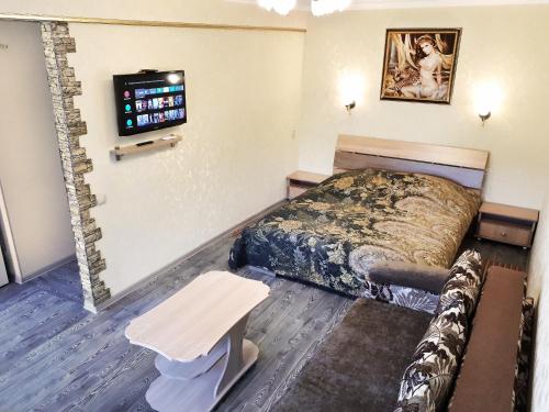 a hotel room with a bed and a table at Lux Apartment on Mayakovsky 6 in Ustʼ-Kamenogorsk