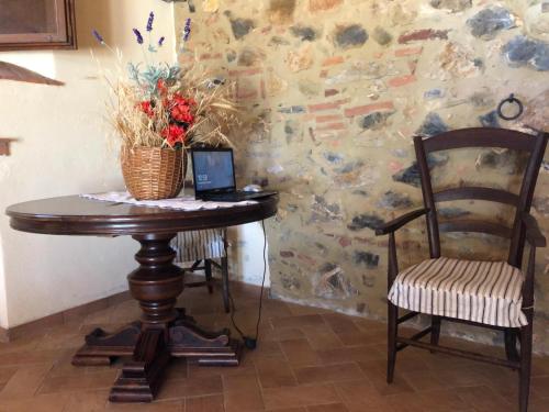 a table with a laptop and a chair in a room at Agriturismo Lupo Vecchio in Grosseto
