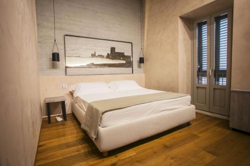 a bedroom with a bed and a painting on the wall at Edward Rooms & Wellness B&B in Trani
