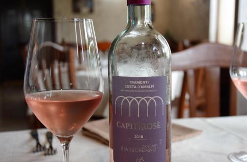 a bottle of wine sitting next to a wine glass at Il Raduno in Tramonti